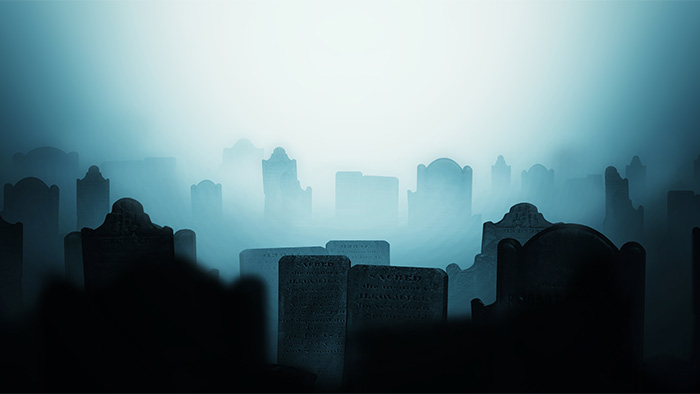 Gravestones silhouetted in the dark